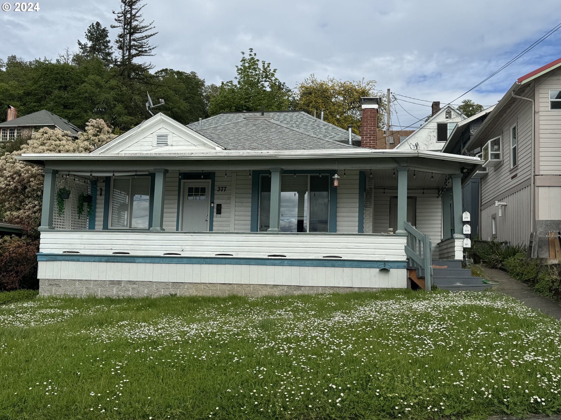 a view of a white house with a large window and a yard