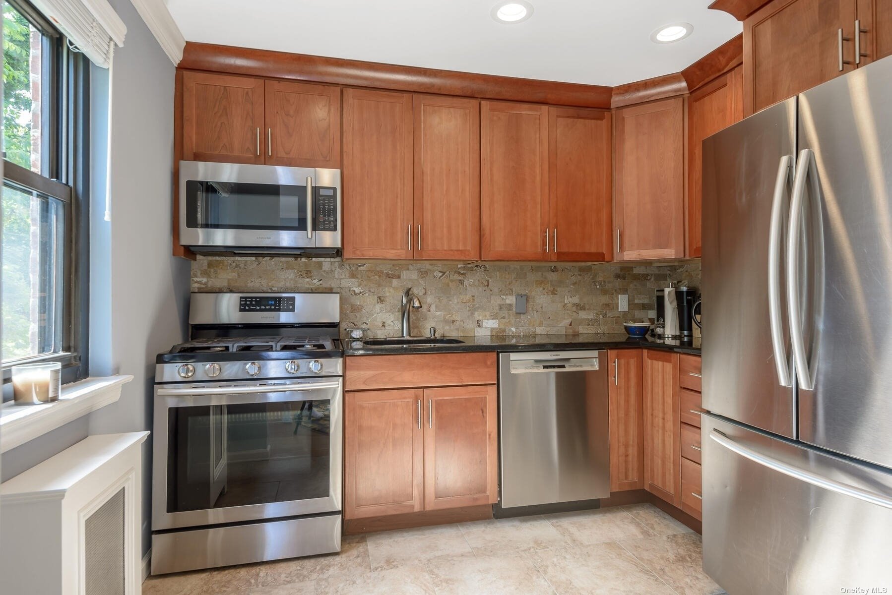 a kitchen with stainless steel appliances granite countertop a refrigerator stove and microwave