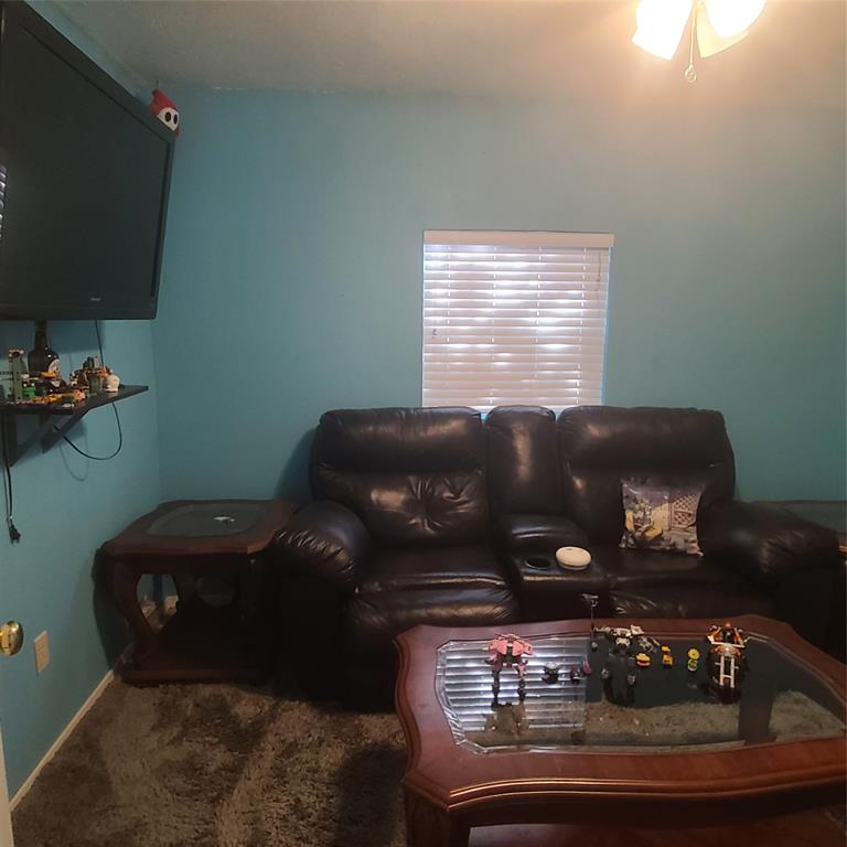 a black leather couch sitting in a living room with furniture