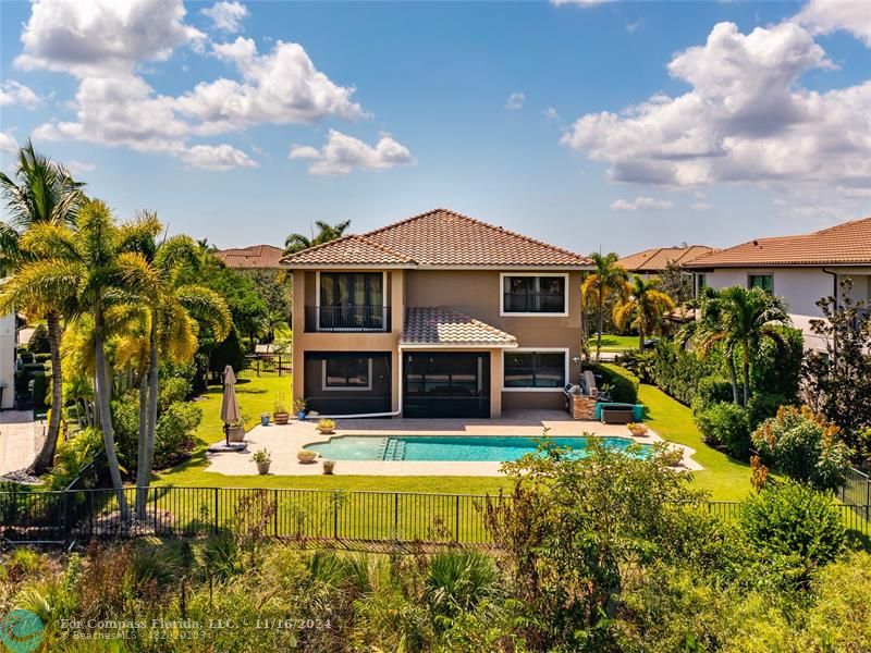 a view of a house with swimming pool and next to a yard