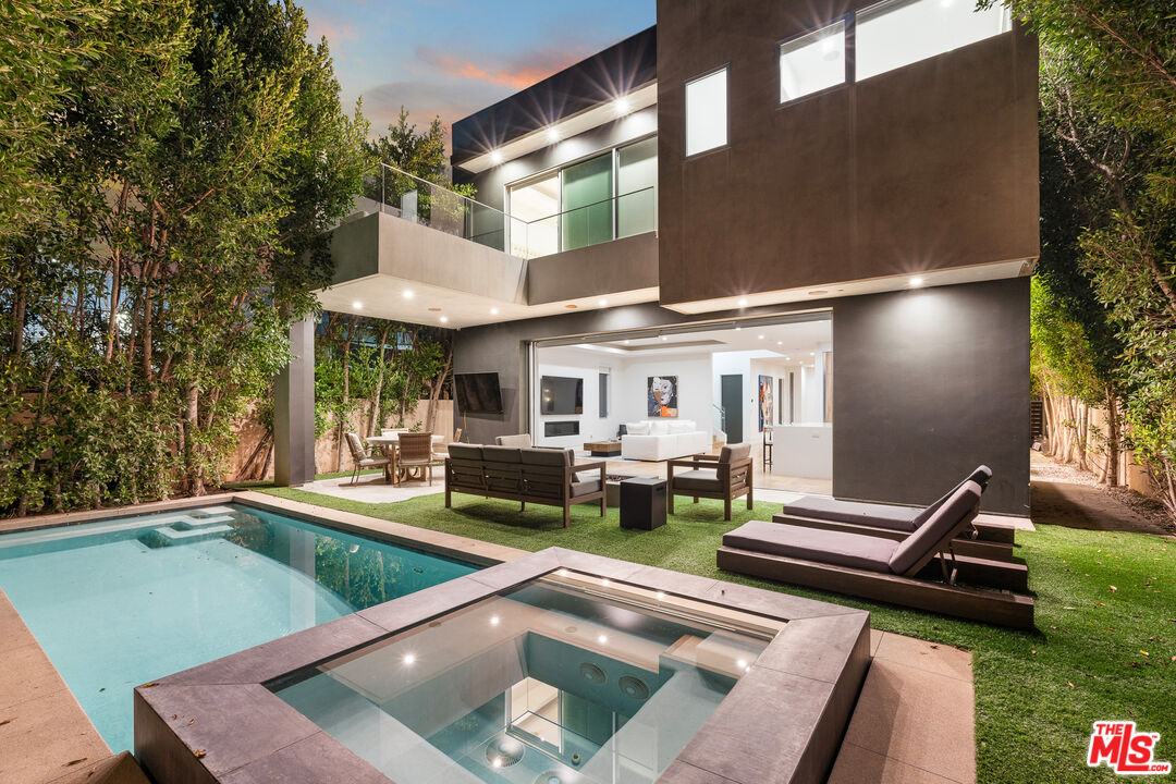 a view of an house with backyard swimming pool and sitting area