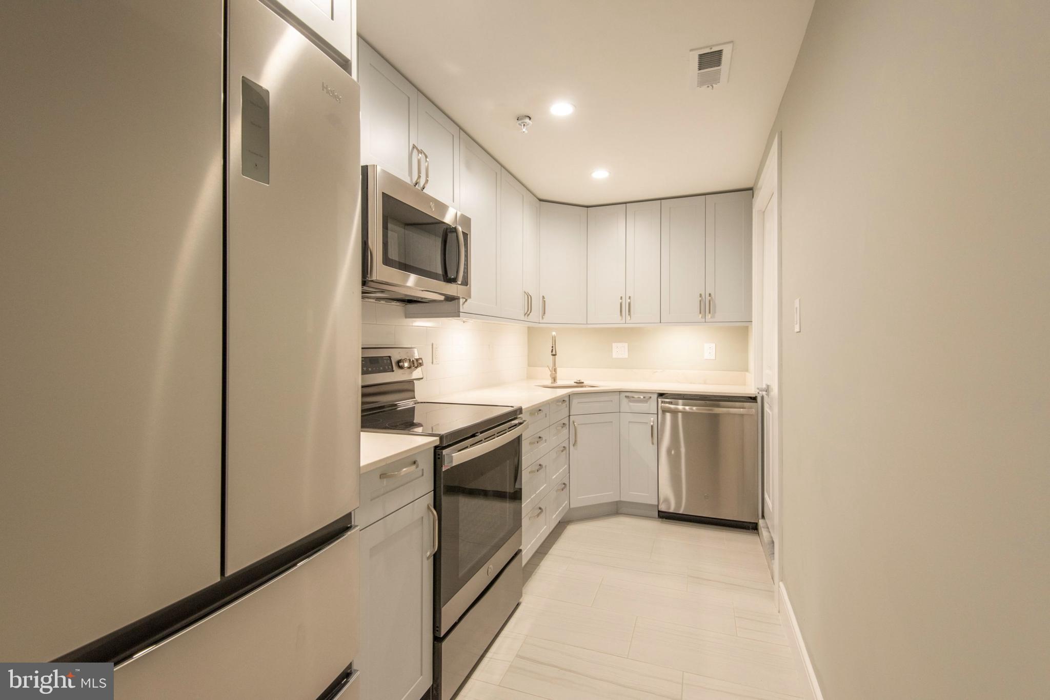 a kitchen with stainless steel appliances granite countertop a refrigerator and a sink