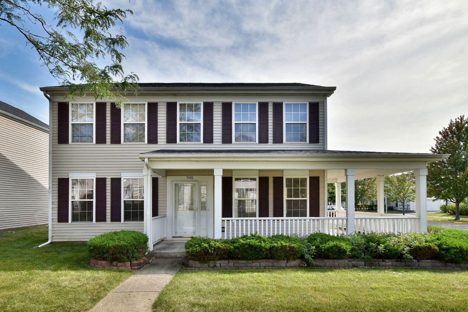 front view of a brick house with a yard