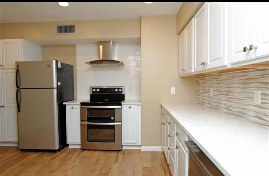 a kitchen with a refrigerator and a stove