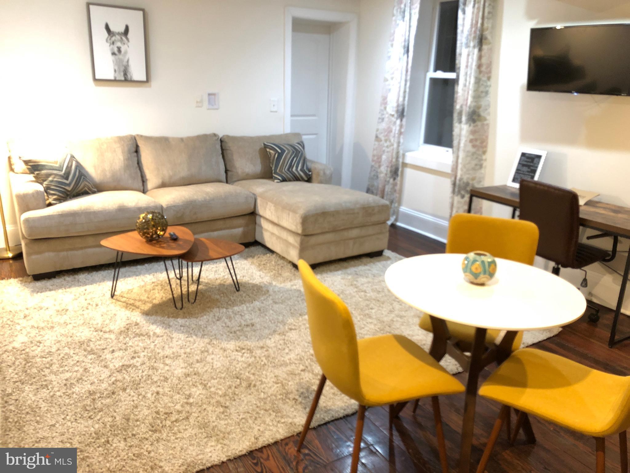 a living room with patio furniture and a flat screen tv