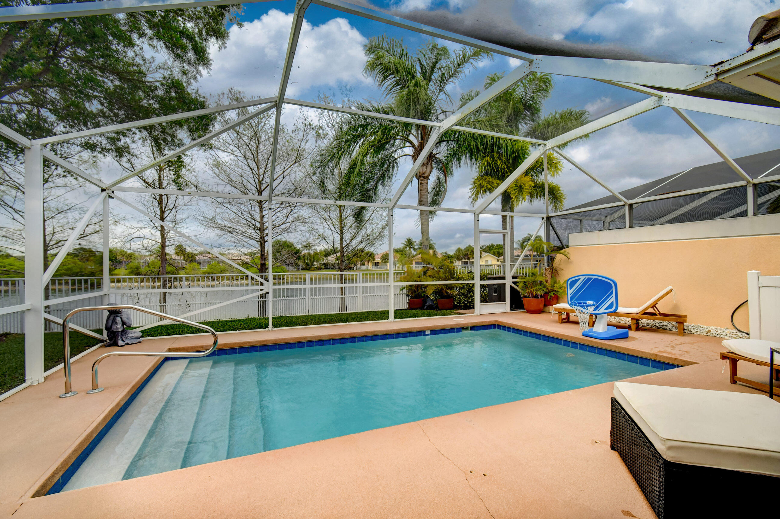 a view of a swimming pool with a patio and a yard