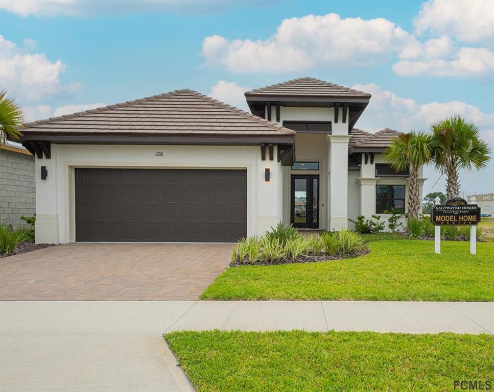 a front view of a house with a garden and yard