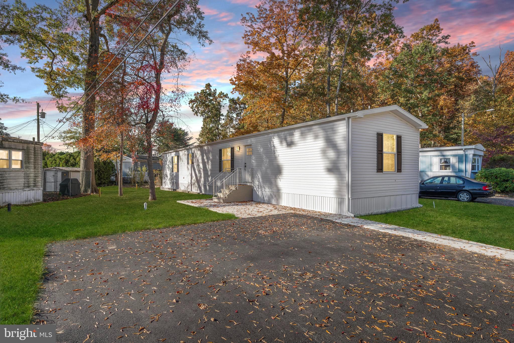 a view of a house with a yard and large trees