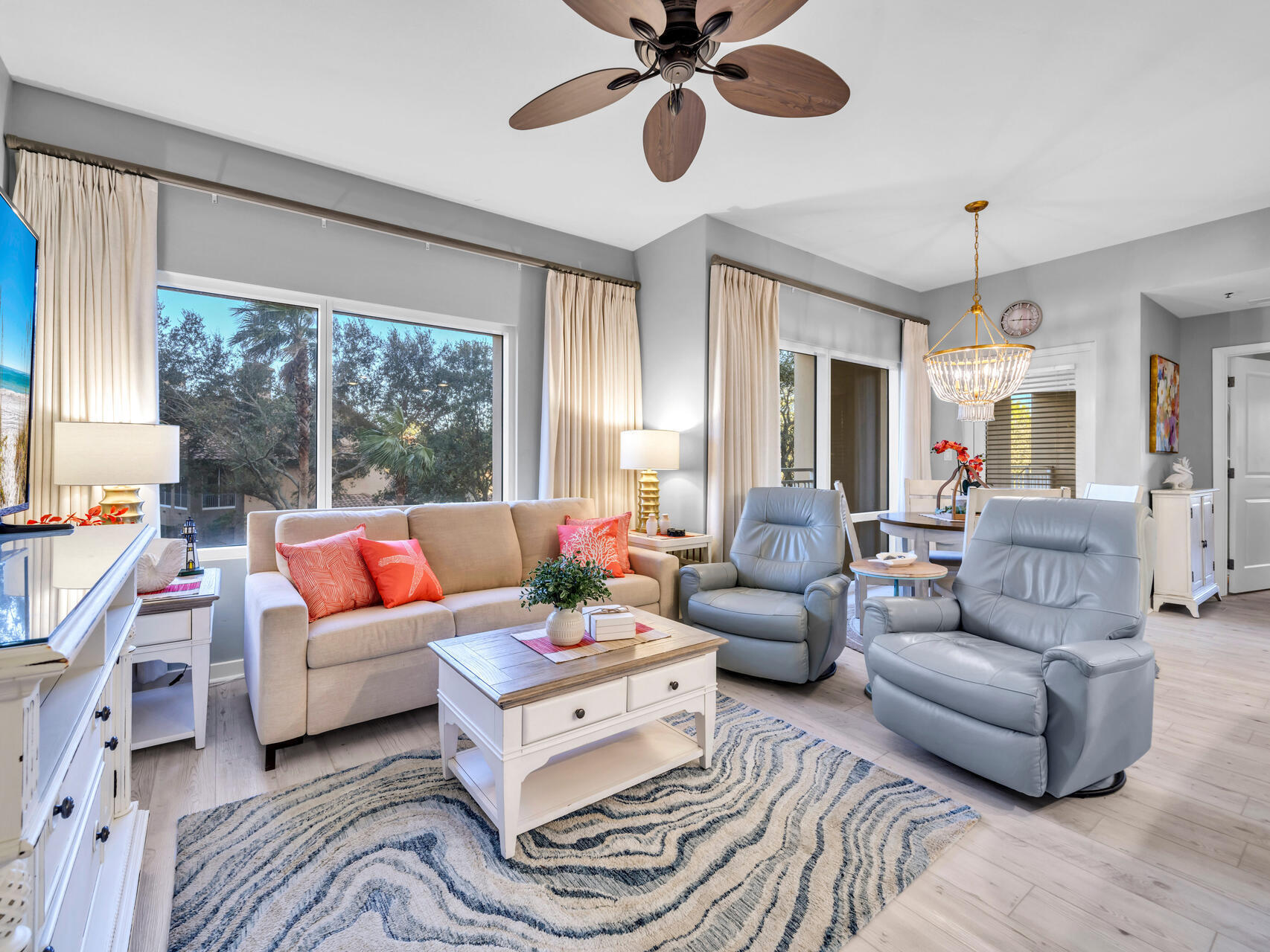 a living room with furniture ceiling fan and a large window