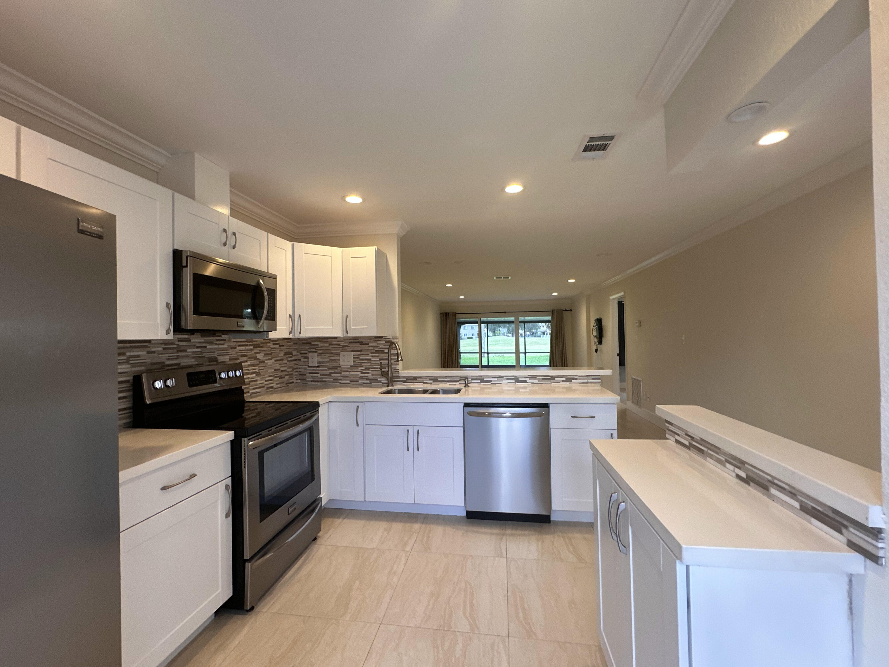 a large kitchen with stainless steel appliances granite countertop a stove and a sink