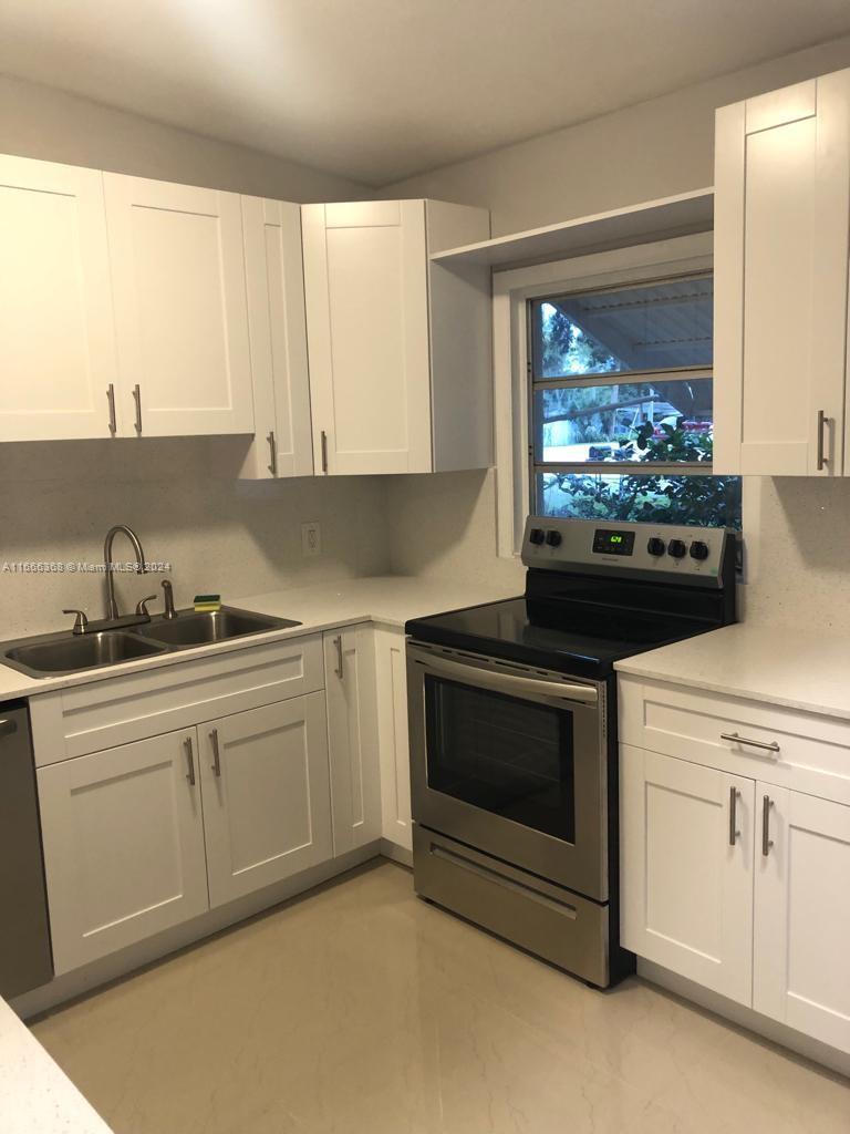 a kitchen with granite countertop white cabinets and white appliances