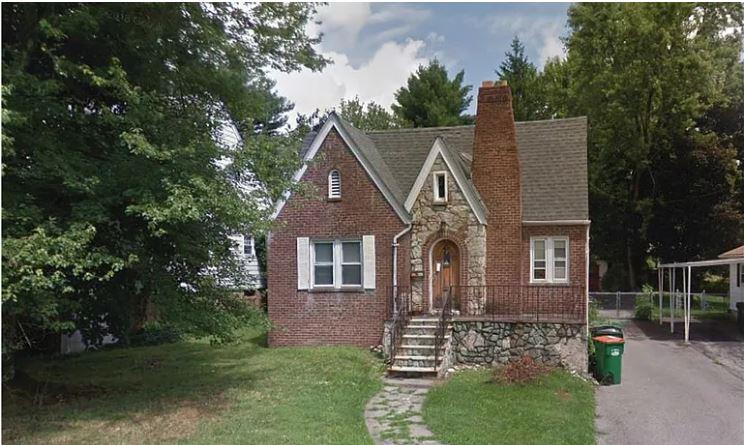 English style home featuring a carport and a front lawn