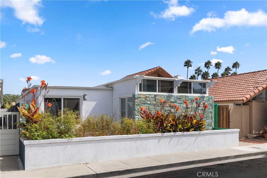 a front view of a house with a yard and potted plants