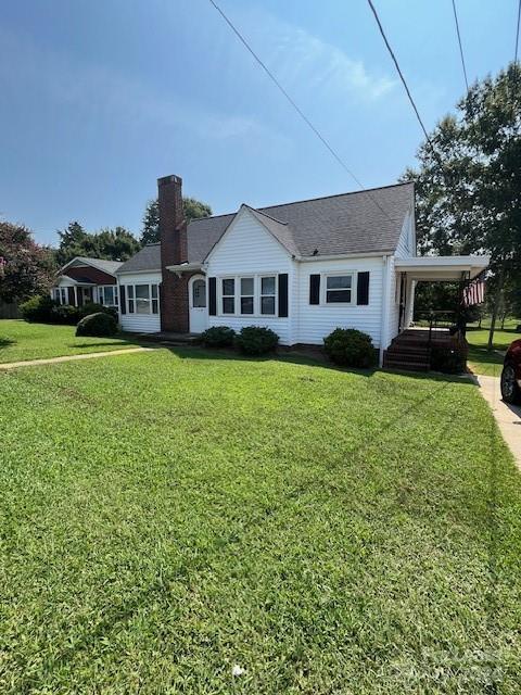 a front view of a house with a yard and trees