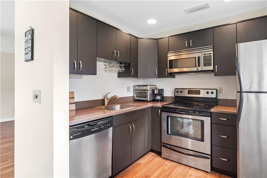 a kitchen with stainless steel appliances granite countertop a stove a sink and a refrigerator