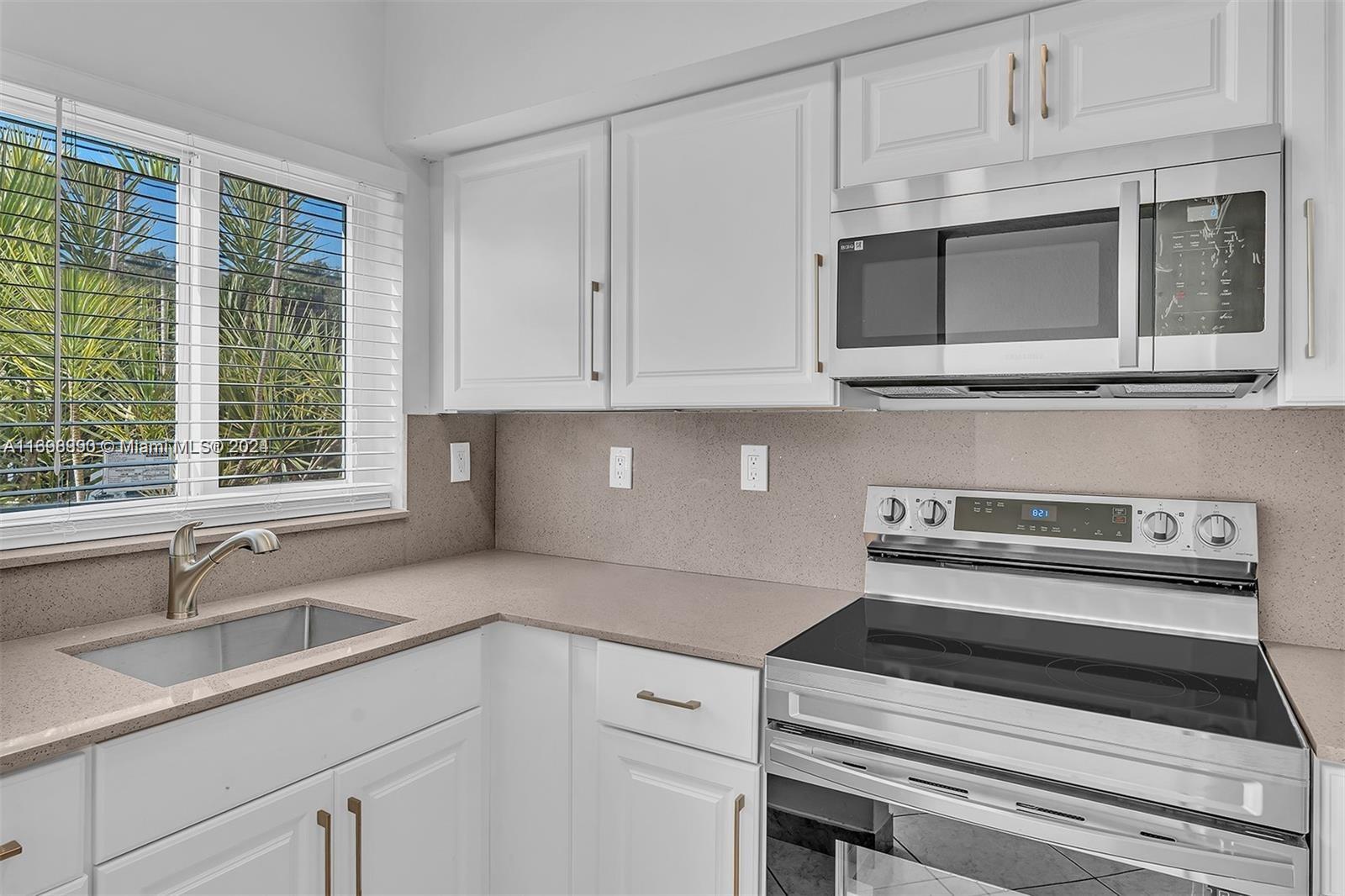 a kitchen with appliances a sink and cabinets