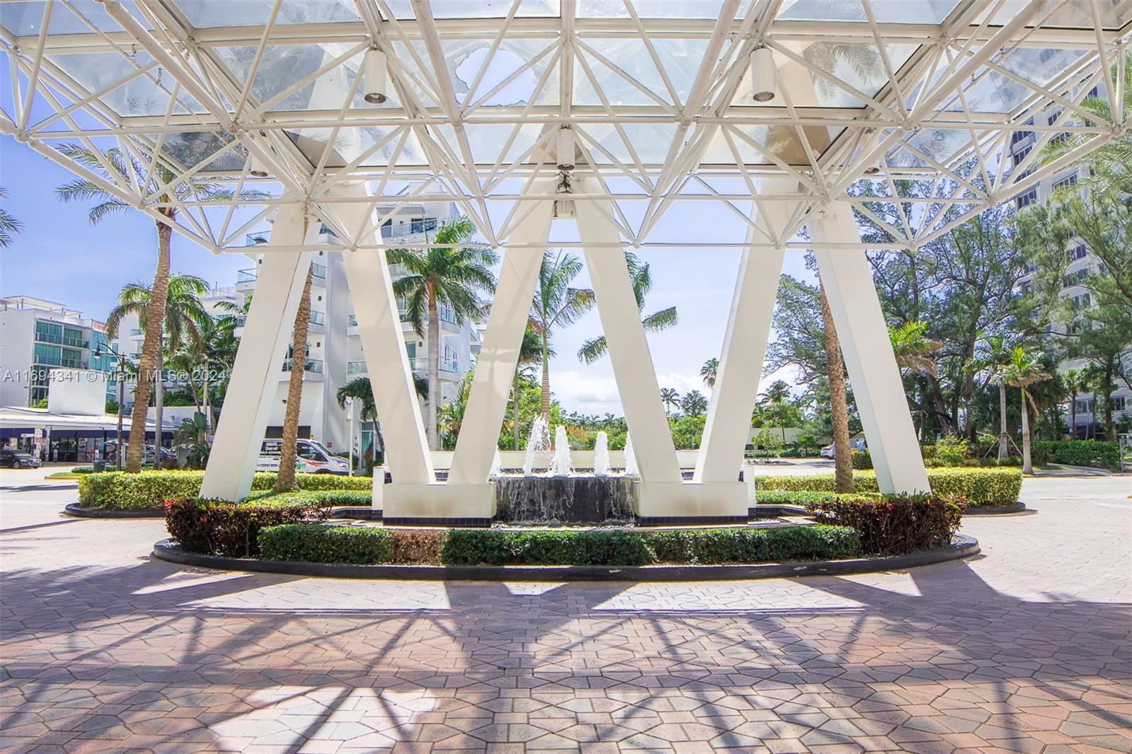 a front view of a building with view of a fountain