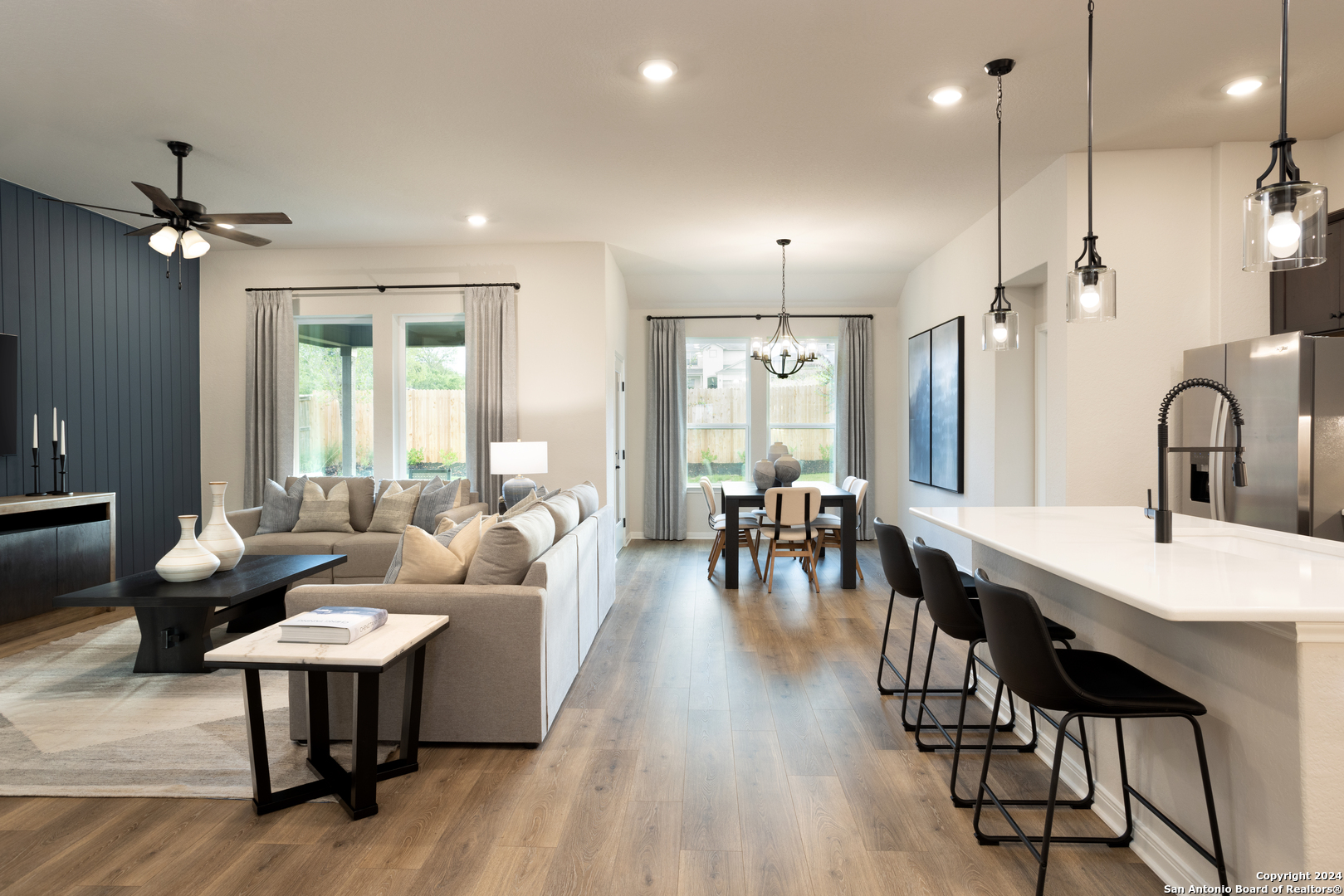 a living room with furniture a table and a large window