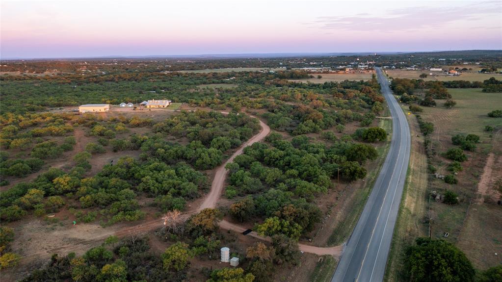 an aerial view of residential houses with outdoor space and trees