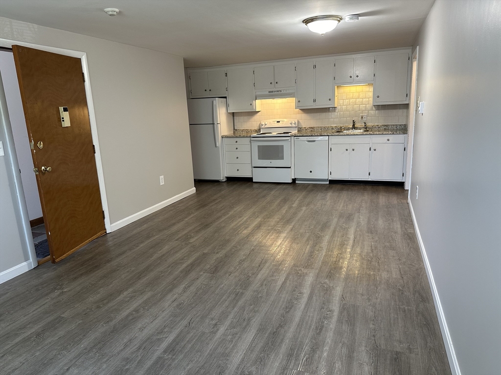 a view of a kitchen with wooden floor and electronic appliances