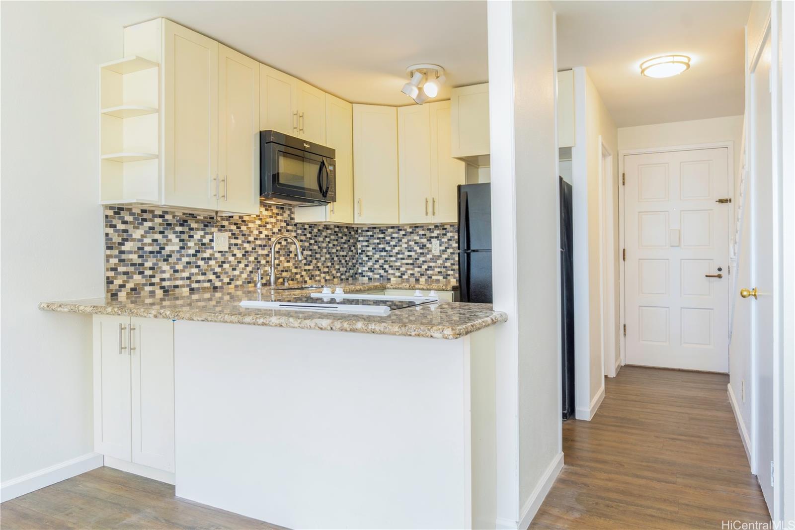 a bathroom with a granite countertop sink a mirror and shower