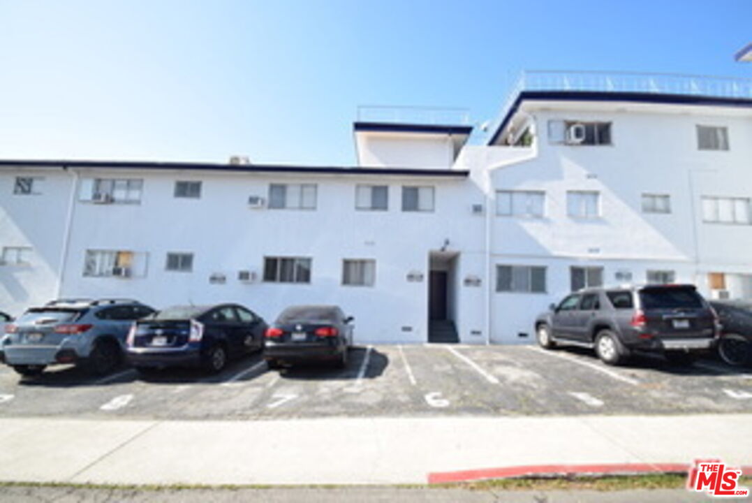 a front view of a house with cars parked