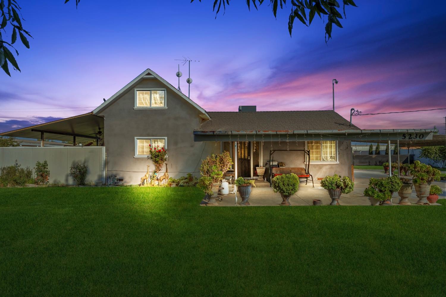 a front view of a house with a yard fire pit and outdoor seating