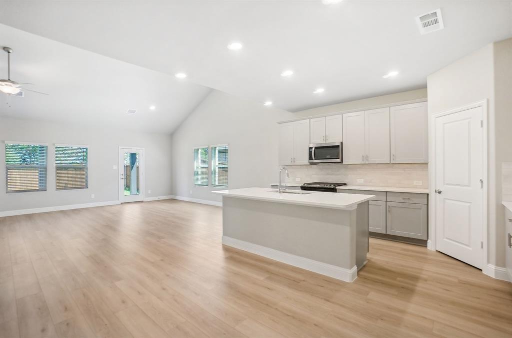 a kitchen with a refrigerator and a stove top oven