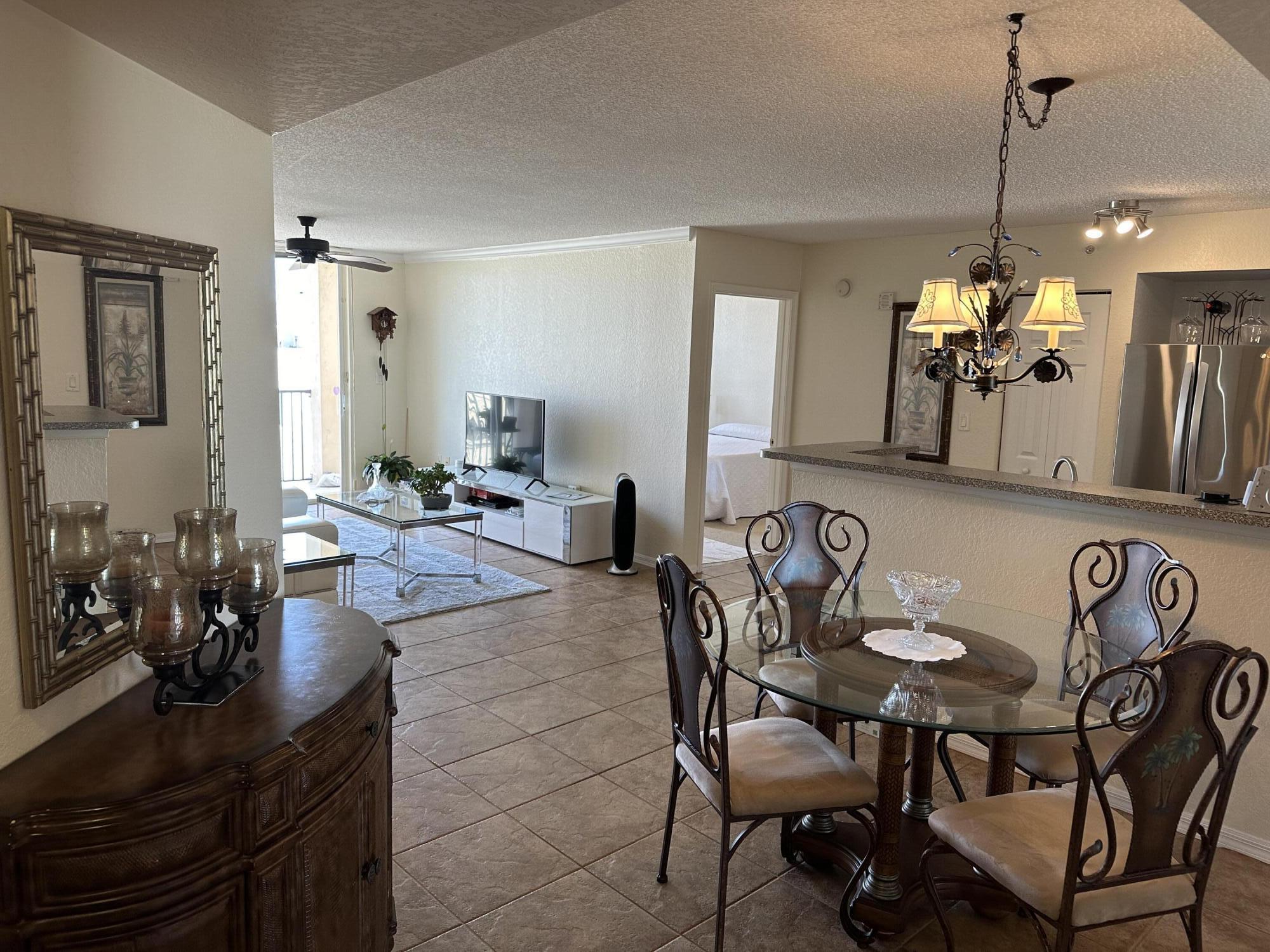 a view of a dining room and livingroom with furniture wooden floor a chandelier