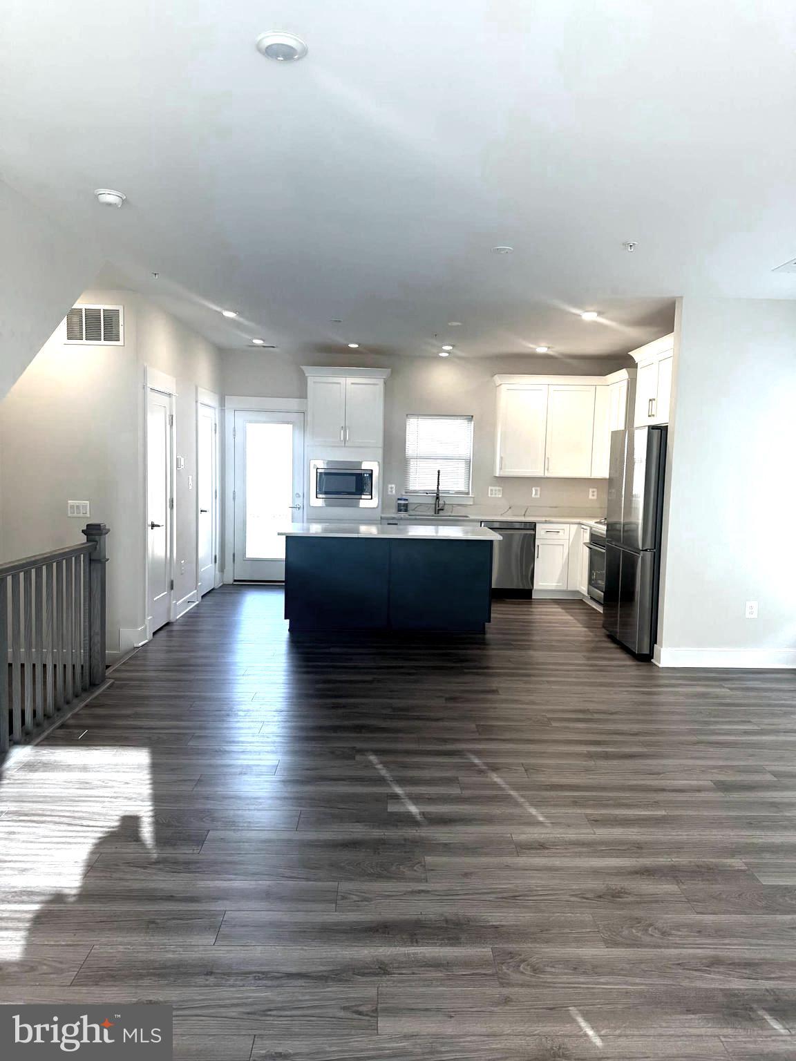 a view of a living room a kitchen and a wooden floor