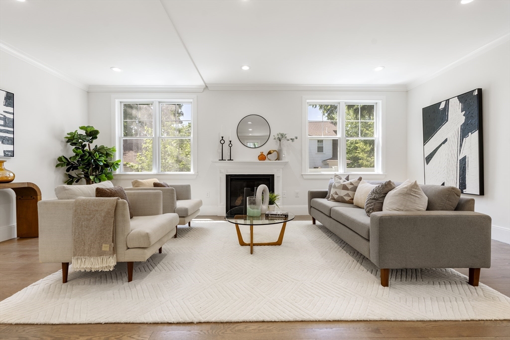 a living room with furniture a large window and a fireplace