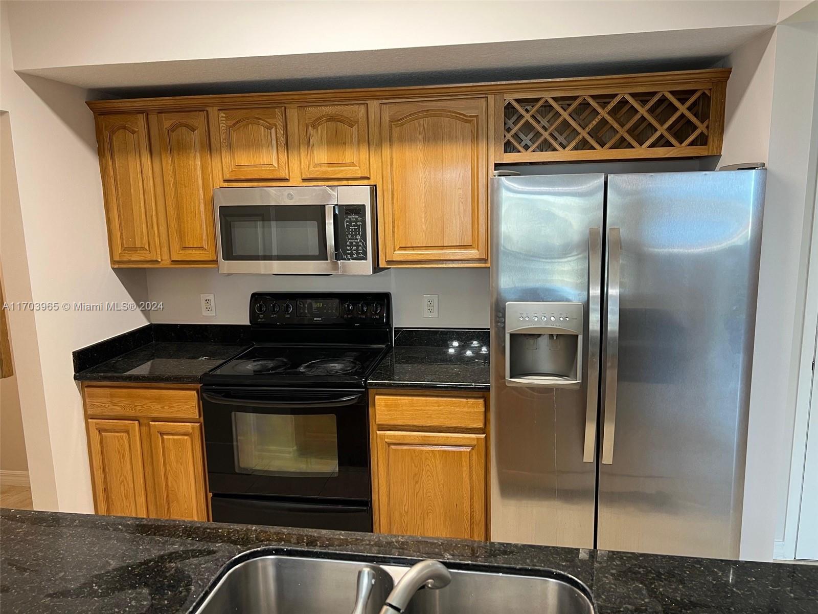 a kitchen with a refrigerator a stove and cabinets