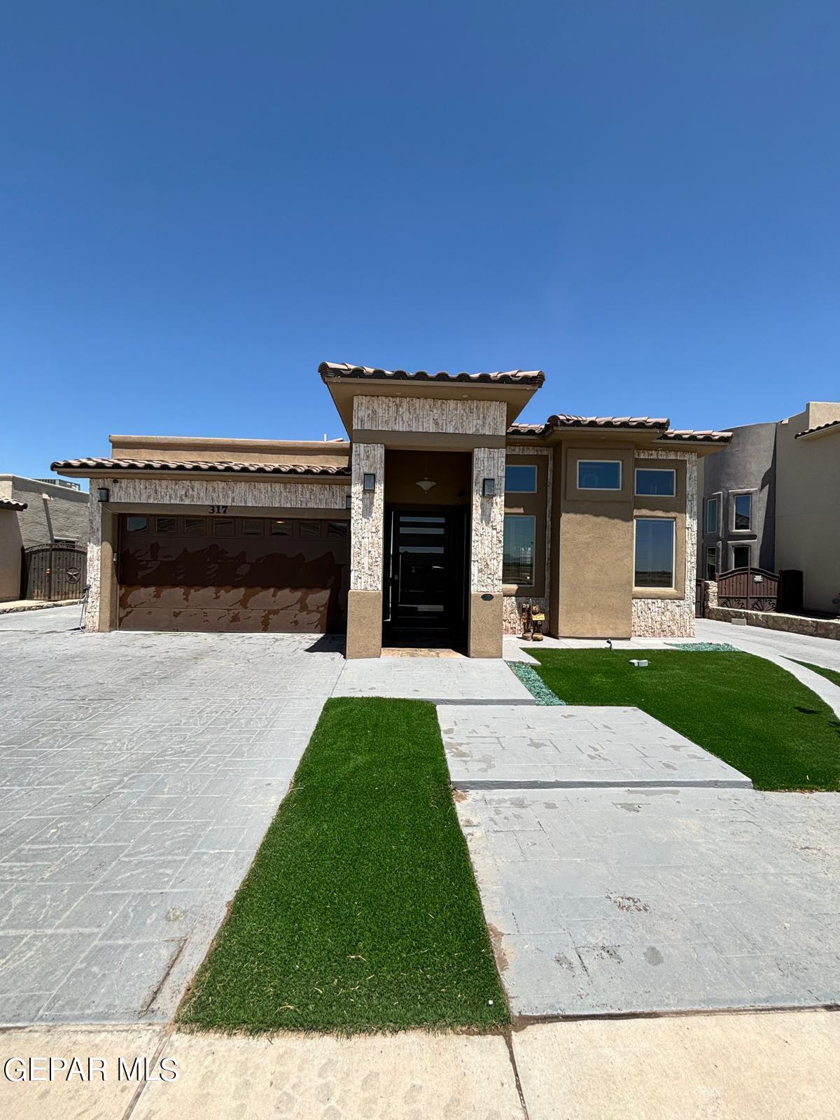 a front view of a house with a garden and yard