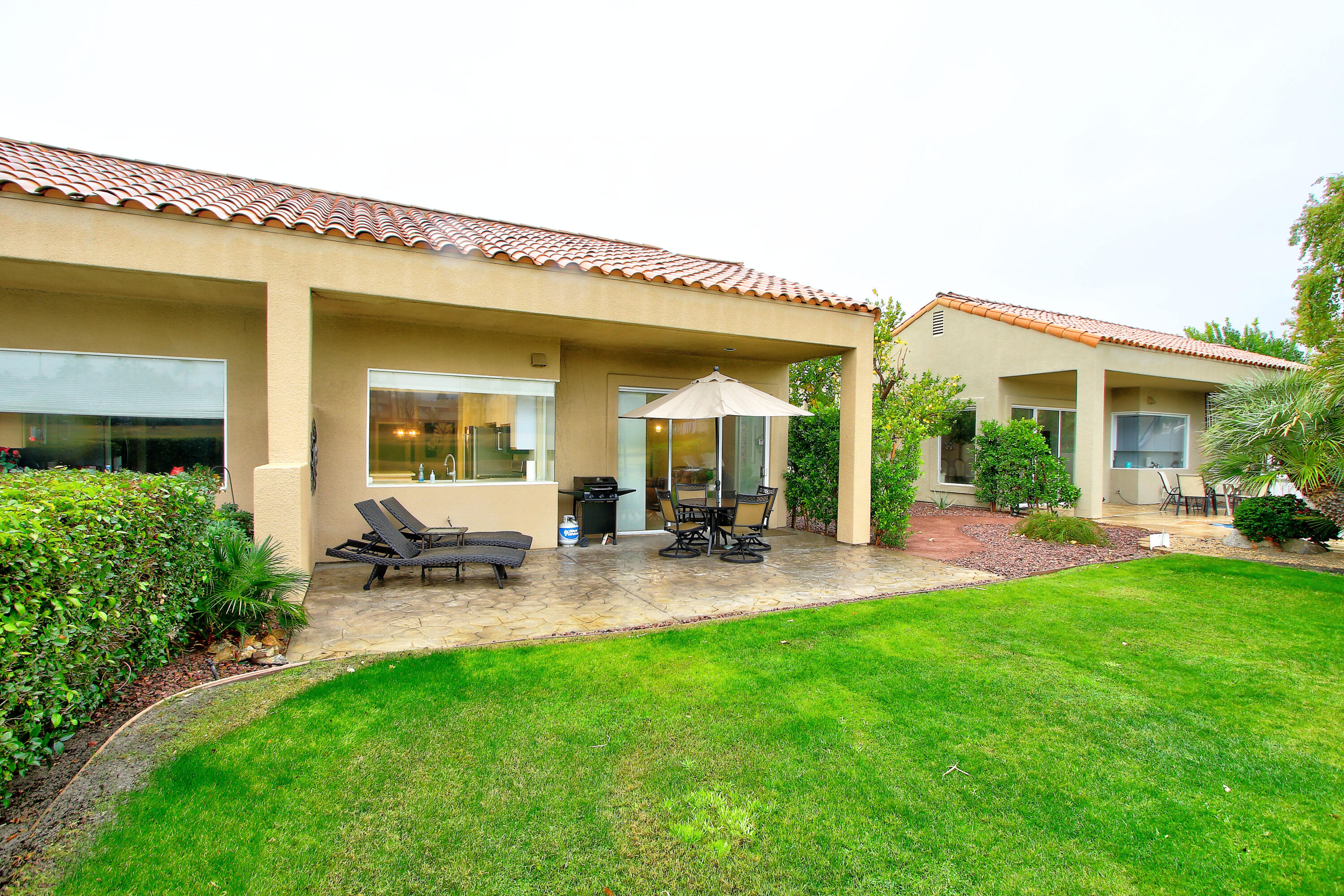 a view of backyard of house with outdoor seating and green space