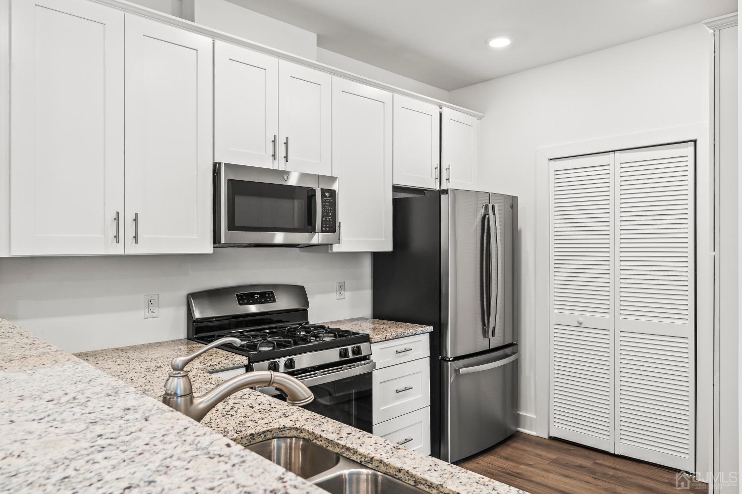 a kitchen with a refrigerator stove and cabinets