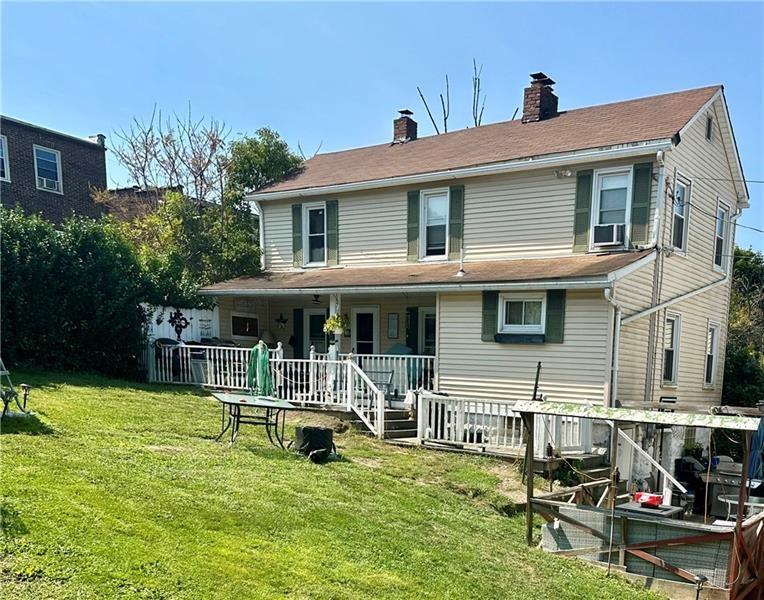 a view of a house with backyard porch and sitting area