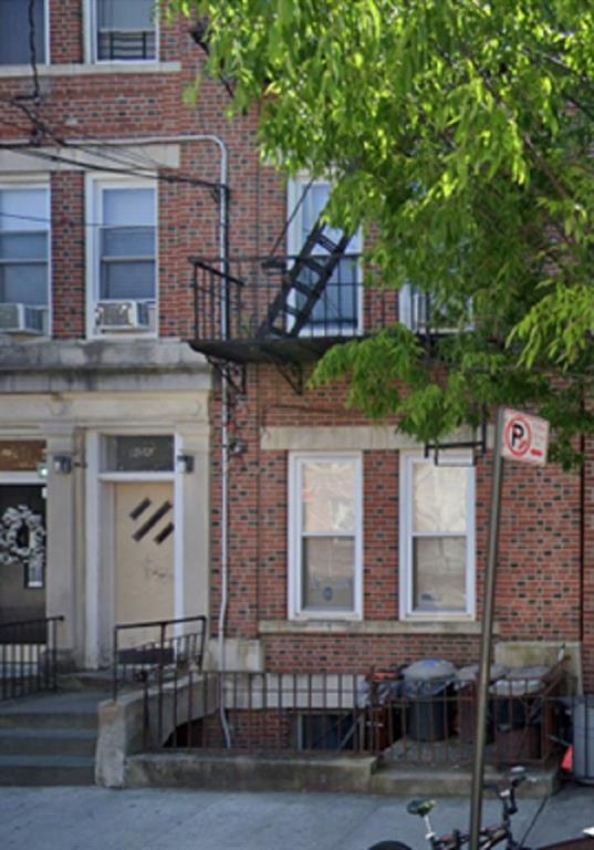 a front view of a house with a tree