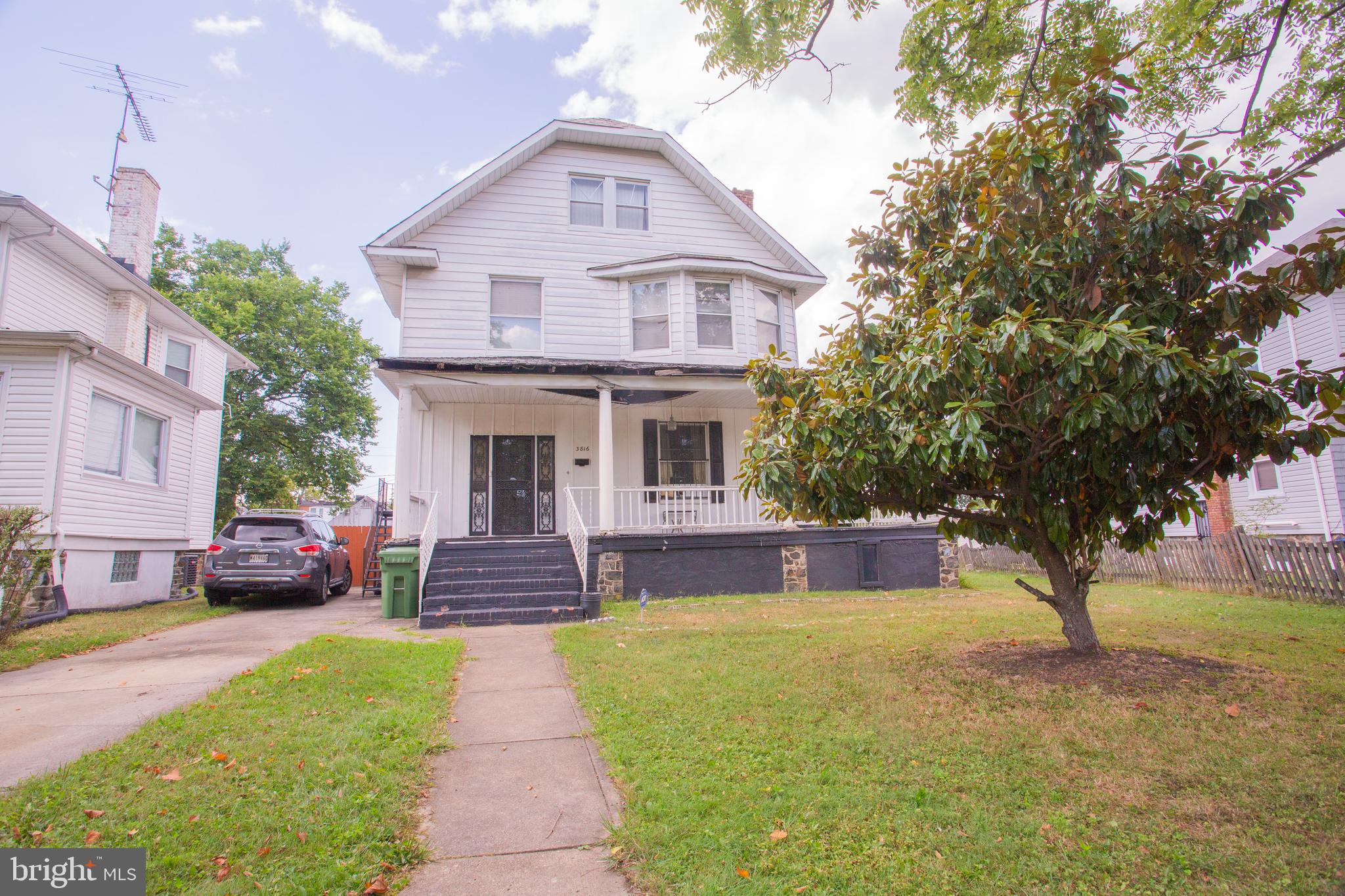 a front view of a house with a garden and trees