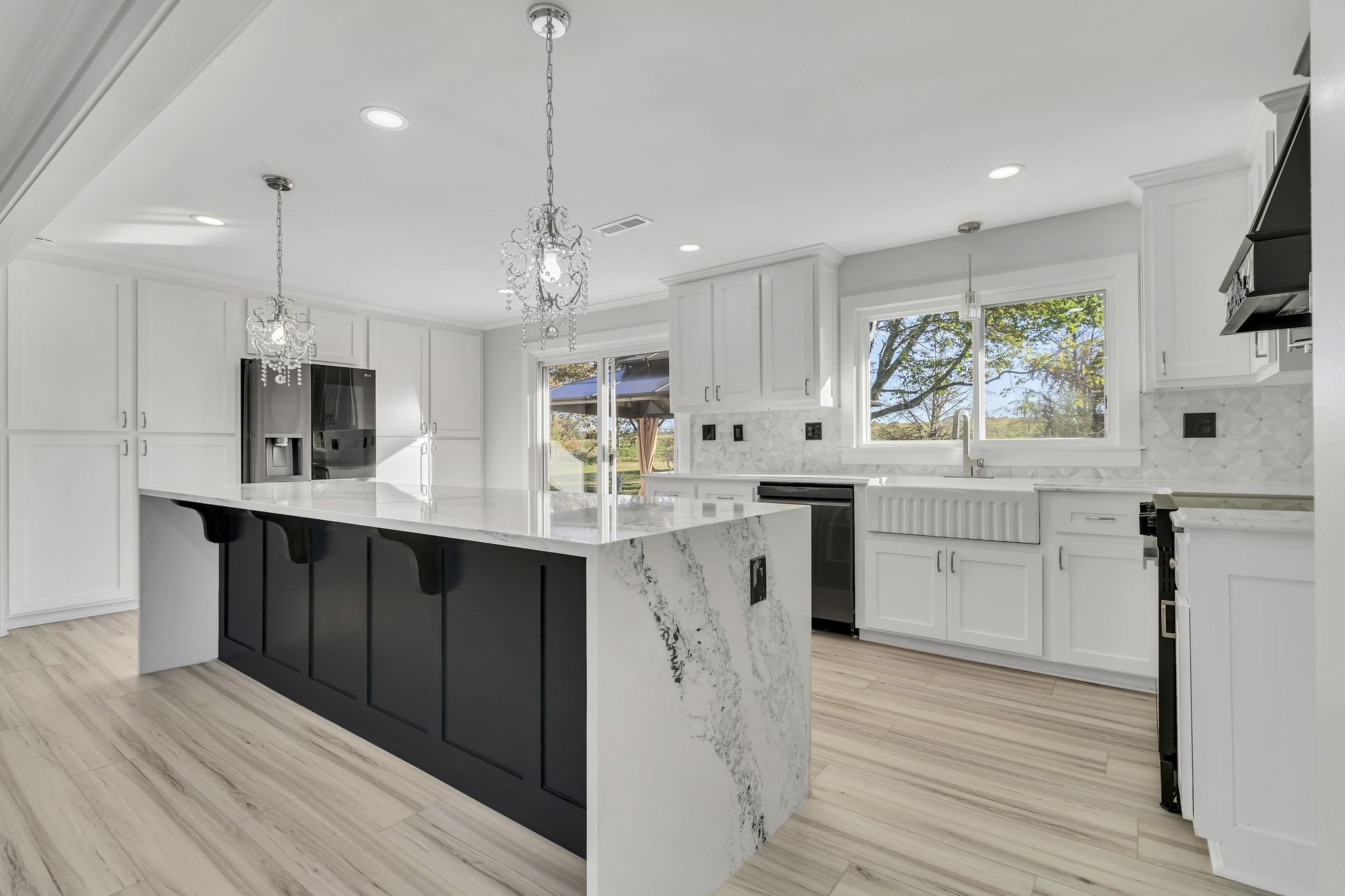 a kitchen with stainless steel appliances kitchen island granite countertop a sink refrigerator and cabinets