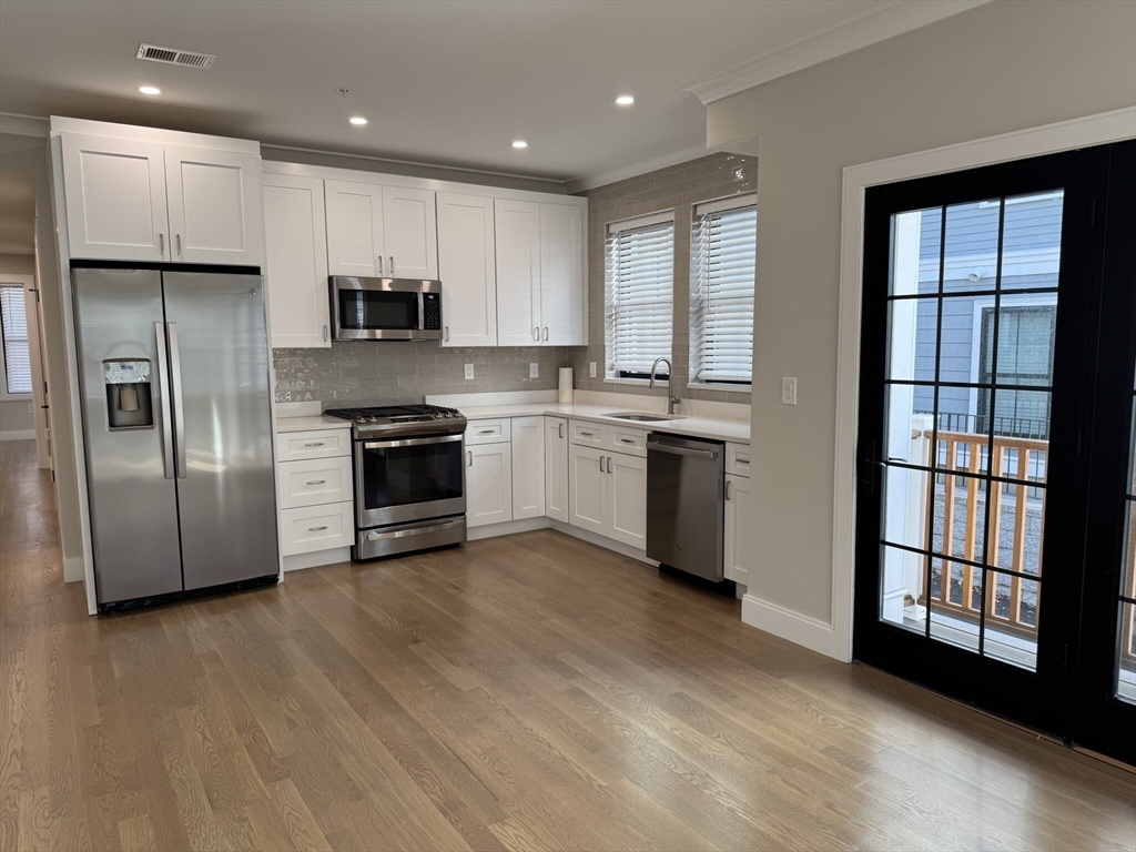 a kitchen with stainless steel appliances granite countertop a stove a sink and a refrigerator