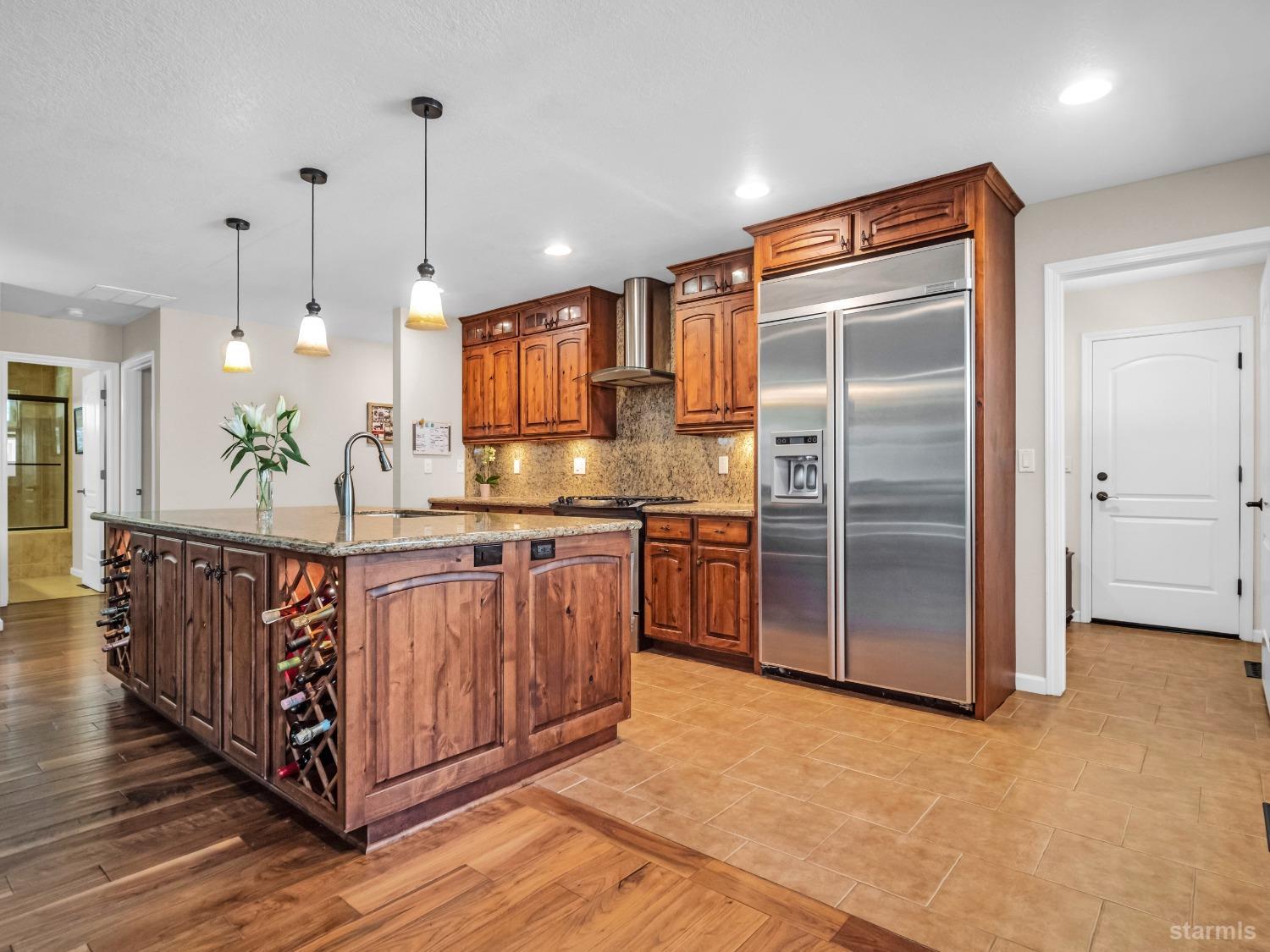 a kitchen with stainless steel appliances granite countertop a refrigerator a sink and a stove