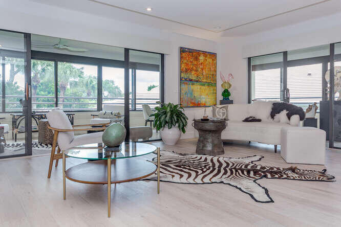 a living room with patio furniture and a large window