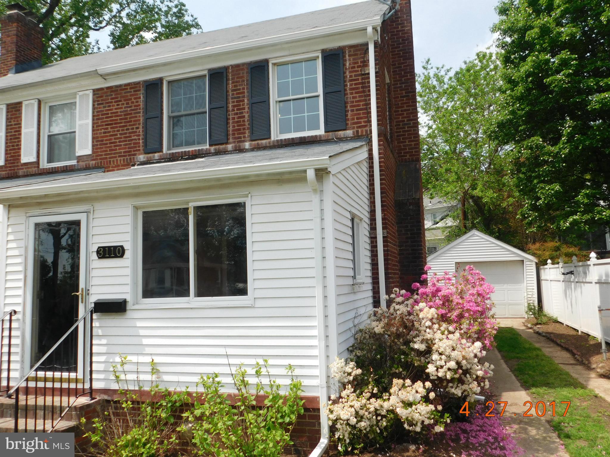 a front view of a house with lots of flowers