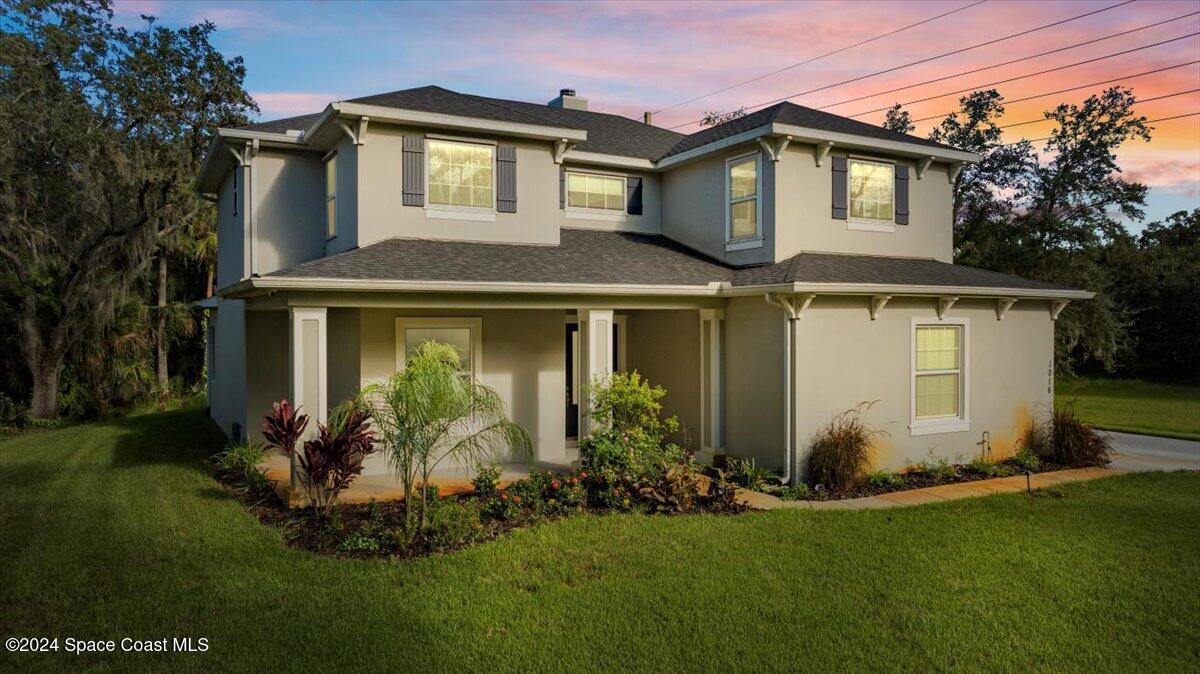 a front view of a house with a garden and plants