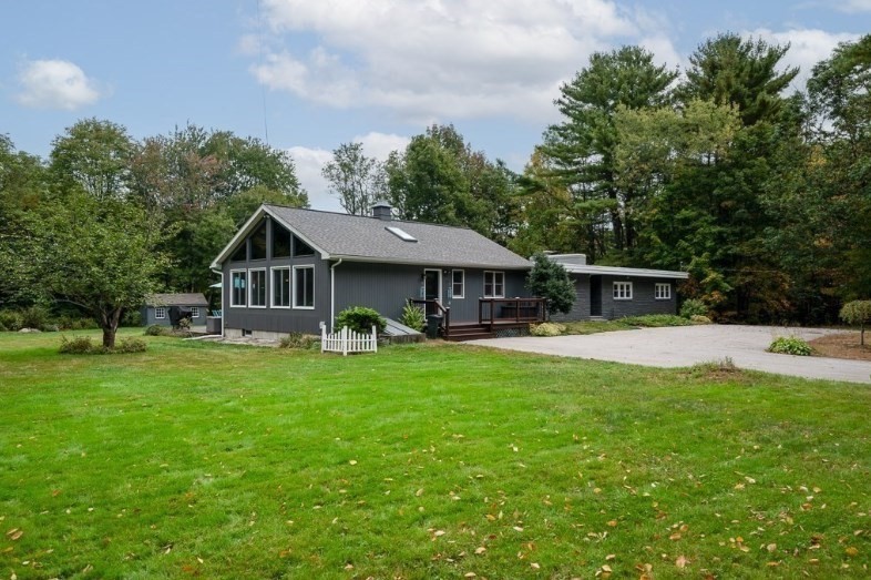 a front view of a house with yard patio and green space