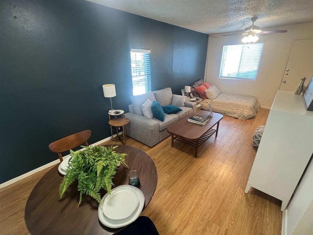 a living room with furniture and a wooden floor