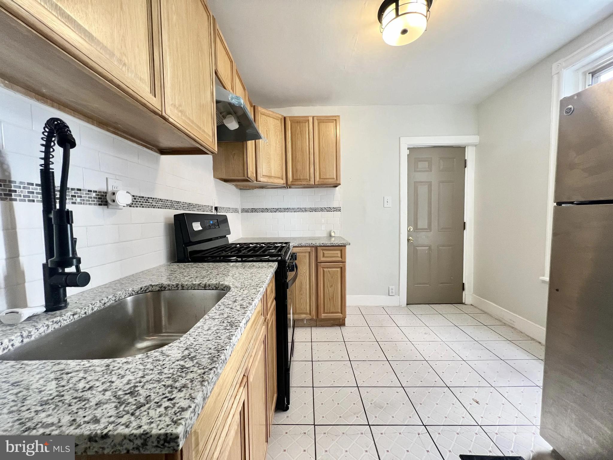 a kitchen with a sink a refrigerator and cabinets