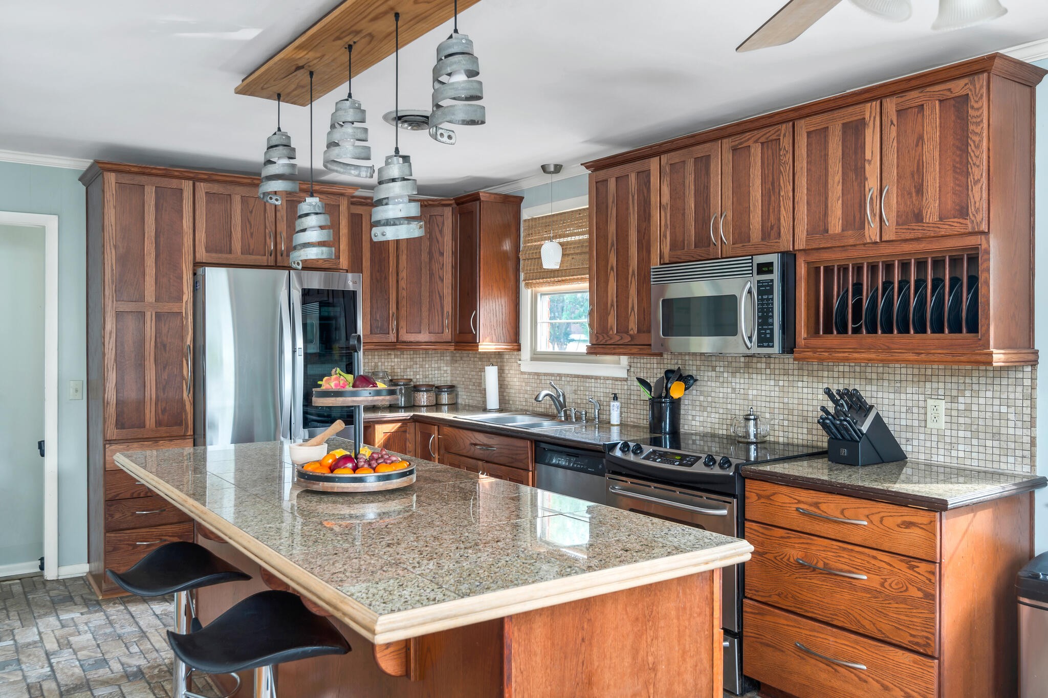 a kitchen with stainless steel appliances granite countertop a sink refrigerator and cabinets