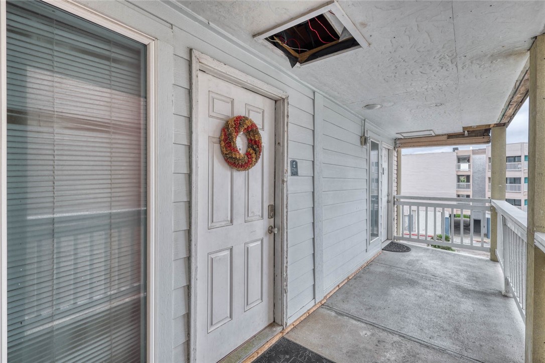 a view of a hallway with wooden floor and windows