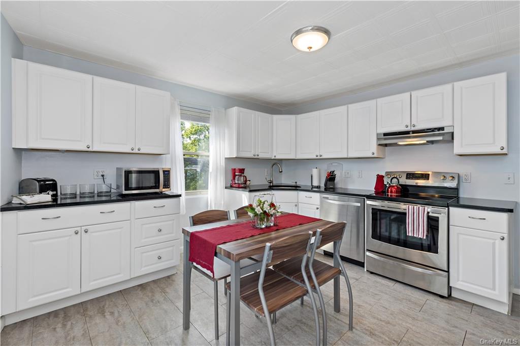 a kitchen with granite countertop white cabinets and white appliances